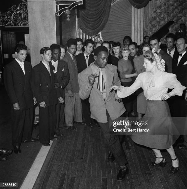 Crowd gathers to watch a black man dancing with a white woman on centre stage at the Paramount Salon de Danse in Tottenham Court Road, London, June...