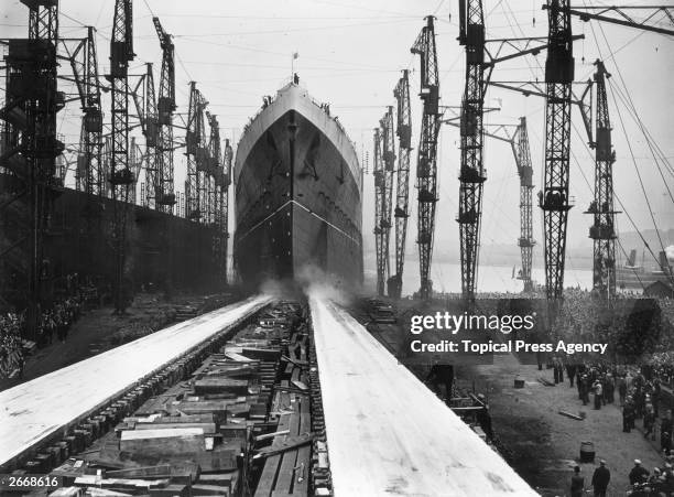 The stately Cunard liner Queen Elizabeth, the largest liner ever built makes her way down the slips on the day of her launch from the John Brown & Co...