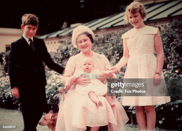 Queen Elizabeth, the Queen Mother sits with her grandchildren Prince Charles, Princess Anne and baby Prince Andrew, the children of Queen Elizabeth...