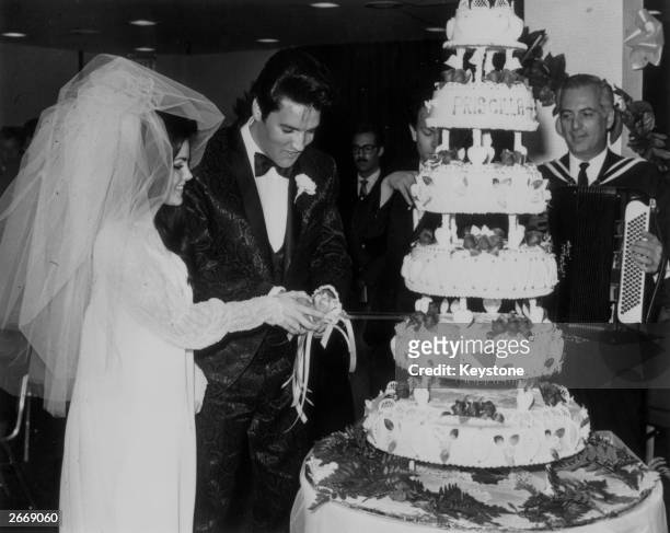 Elvis Presley cutting the six-tier wedding cake with his bride Priscilla Beaulieu at the Aladdin Hotel, Las Vegas.