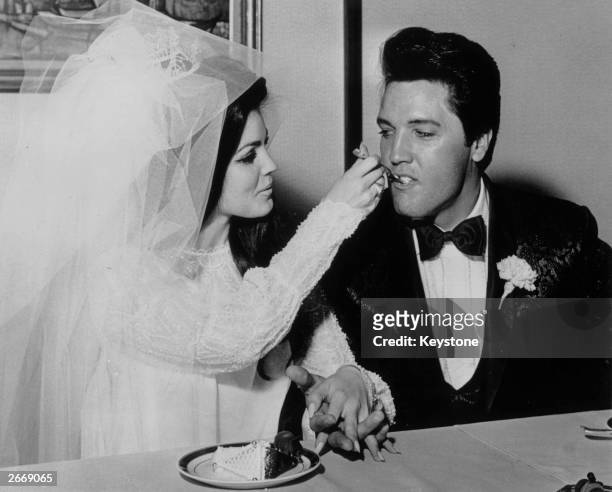 Elvis Presley being fed a mouthful of wedding cake by his bride Priscilla Beaulieu at the Aladdin Hotel, Las Vegas.