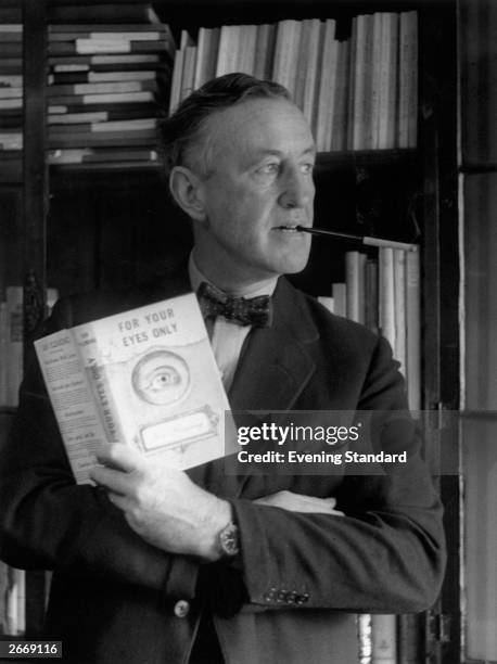 English author Ian Fleming in his study with a copy of 'For Your Eyes Only', one of the series of James Bond novels that he wrote.