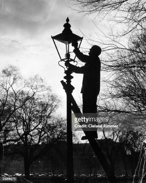 Joe Styles from Putney, London who has a been a lamp lighter for 40 years, cleaning a lantern in Hyde Park, London. He has 183 gas lamps in his care.