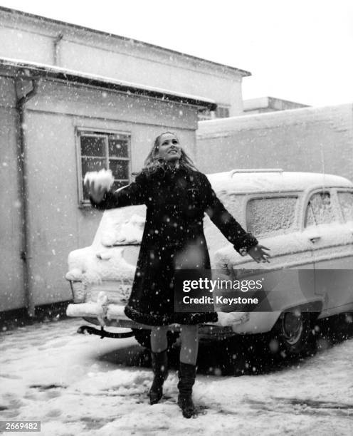 Swiss actress Ursula Andress plays in the snow on the last day of filming for the James Bond film 'Casino Royale', 15th April 1966.
