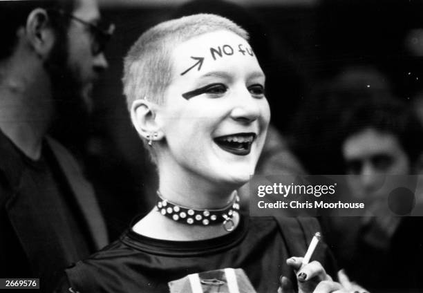 Girl wearing punk clothes and make up, including the words 'No Future' across her forehead, waiting outside the Rainbow Theatre, London, before a Jam...