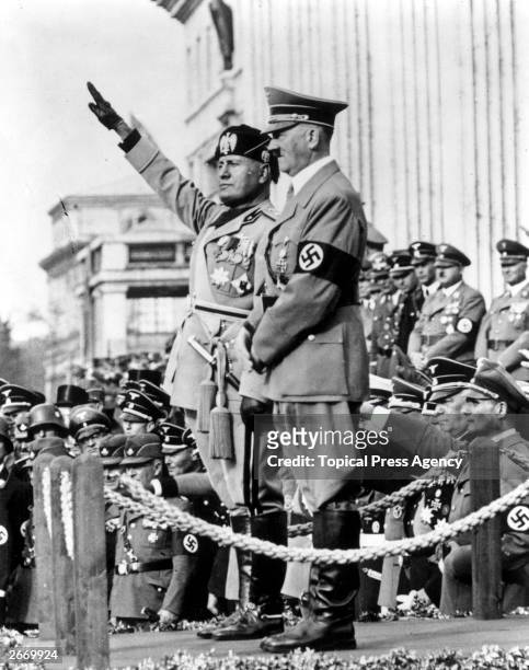 Italian dictator Benito Mussolini saluting next to German dictator Adolf Hitler outside the Temple of Heroes during a parade in Munich.