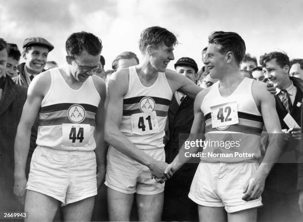 Britain's famed miler Roger Bannister being congratulated by Chris Chataway after setting a new record of 3 minutes 59.4 seconds. On the left is...