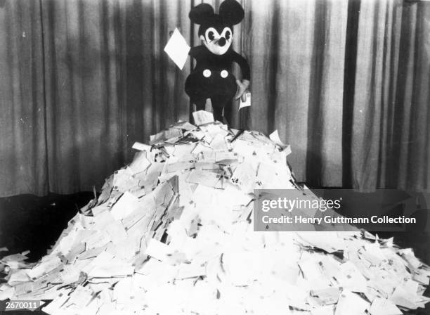 Cartoon character Mickey Mouse on top of a pile of letters that he has received from fans.