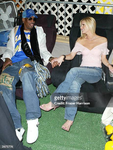Former NBA player Dennis Rodman and actress Brande Roderick sit on the Sharper Image massage chairs at the 2003 Tall Pony Radio Music Awards gift...