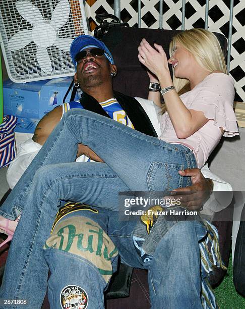 Former NBA player Dennis Rodman and actress Brande Roderick sit on the Sharper Image massage chairs at the 2003 Tall Pony Radio Music Awards gift...