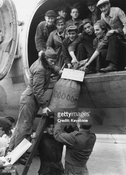 The millionth bag of coal to be delivered during the Berlin Airlift handed down from a US Skymaster to pilot Sergeant Clyde Peterson and Group...