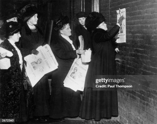 New York suffragettes putting up posters announcing a forthcoming lecture by British suffragette and feminist Sylvia Pankhurst. On the right is...