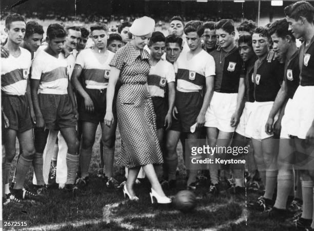Eva Peron , former actress and wife of Argentinian President, Juan Peron and commonly known as Evita, takes the first kick in a football match. She...