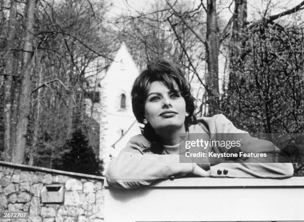 Film star Sophia Loren leans on the gate of her home in Switzerland where she is resting from between films.