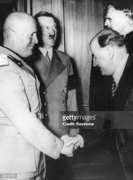 Mussolini shaking hands with Edouard Daladier on the occasion of the signing of the Munich Declaration. Adolf Hitler and Neville Chamberlain are in...