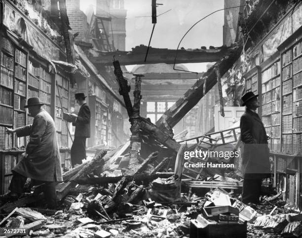 Readers choosing books which are still intact among the charred timbers of the Holland House library, London, 23rd October 1940.