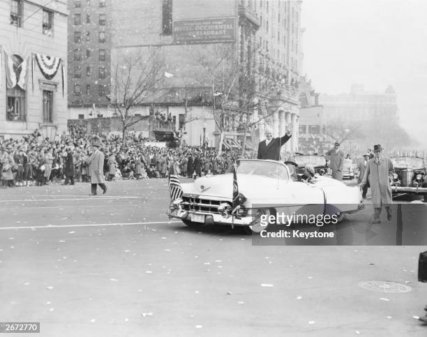 34th president of the United States Dwight David Eisenhower waves to the crowds, from his open-topped Cadillac Eldorado, after his Inauguration...