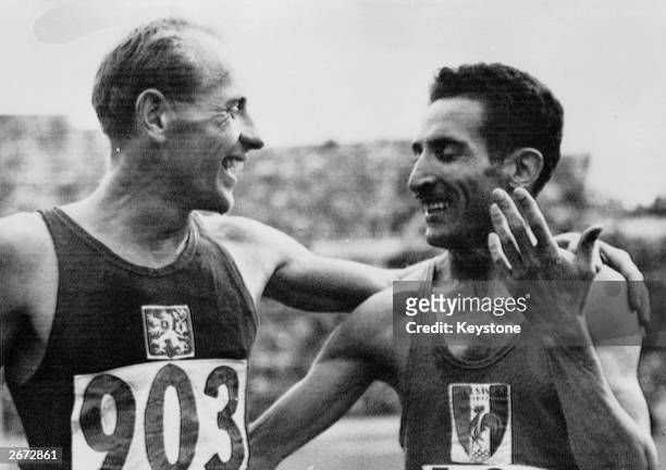 Emil Zatopek of Czechoslovakia is congratulated by Alain Mimoun O'Kacha of France after winning the 5,000 metres at the 1952 Helsinki Olympics....