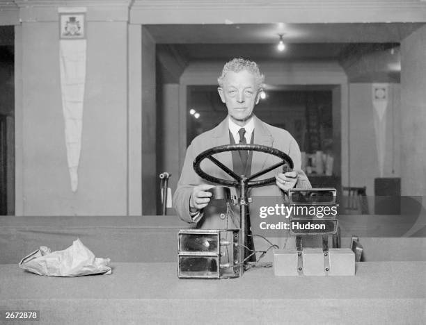 Sykes with his invention of motor car signals which are controlled from a steering wheel column, on display at the International Exhibition of...