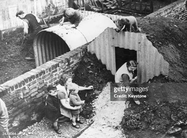Neighbours putting up Anderson Air Raid Shelters in their gardens during the Second World War.