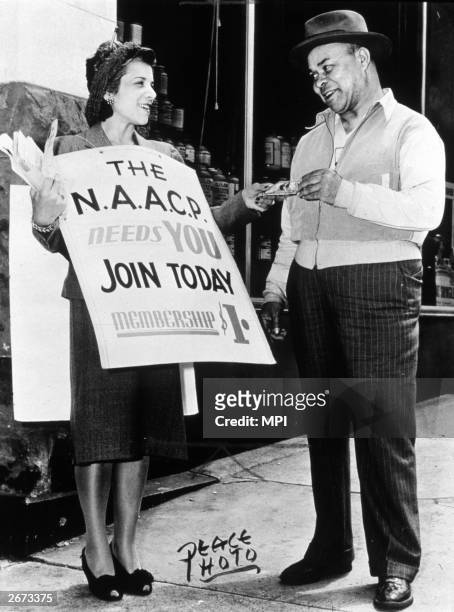 Women hands a flyer to a man looking to join the NAACP . The NAACP was founded in 1909 on Abraham Lincoln's birthday after a riot had broken out the...