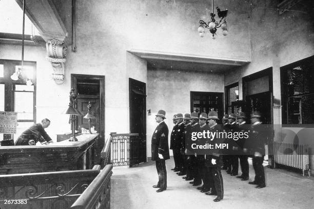 Uniformed police stand to attention behind their sergeant in a NYPD roll call.