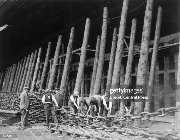 Workmen shoring up the huge bows of the new Cunard White Star liner 534 with timber and chains, prior to her launch from the John Brown & Co...