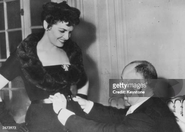 Screen star Jane Russell meets French fashion designer Christian Dior in Paris for a fitting of one of Dior's much vaunted 'H' line creations.