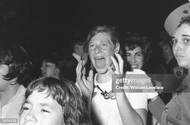 Teenage Beatle fan in hysterics as she catches a glimpse of her heroes.