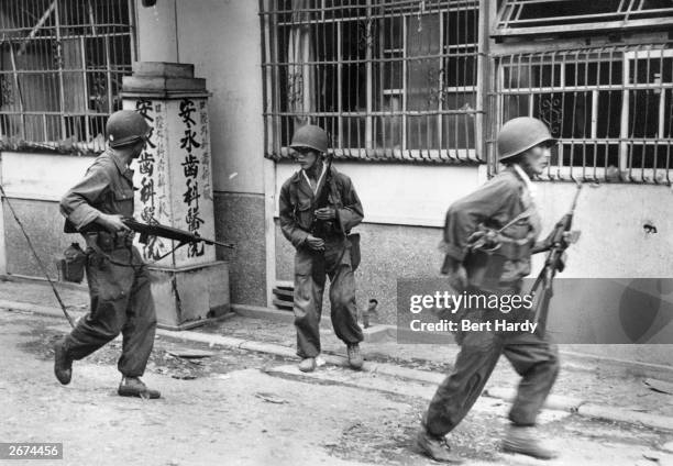 South Korean troops in the streets of Inchon with guns at the ready, following the invasion of the town by United Nations forces. Original...