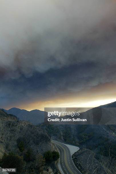 Heavy smoke from an out of control wildfire hangs over the San Bernardino valley October 28, 2003 in Waterman Canyon, California. Wildfires continue...