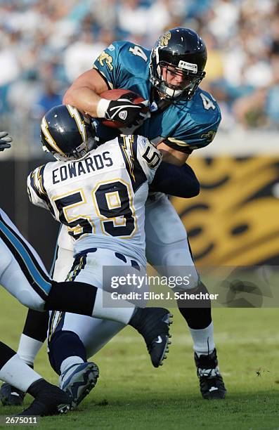 Marc Edwards of the Jacksonville Jaguars is stopped by linebacker Donnie Edwards of the San Diego Chargers on October 5, 2003 at Alltel Stadium in...