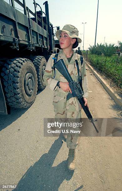 In this handout photo provided by the U.S. Navy, a U.S. Soldier assigned to Expeditionary Strike Group One prepares to distribute water to Iraqis...