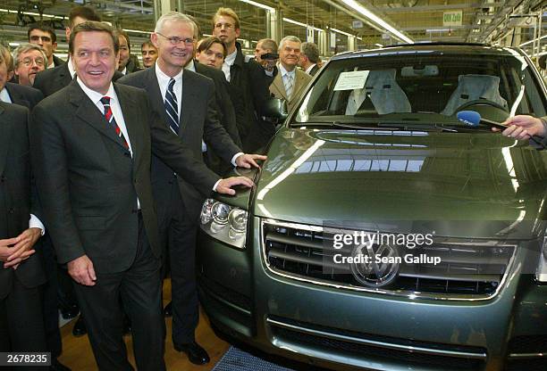 German Chancellor Gerhard Schroeder stands next to a Volkswagen Touareg sport utility vehicle during a tour of a VW factory October 29, 2003 just...