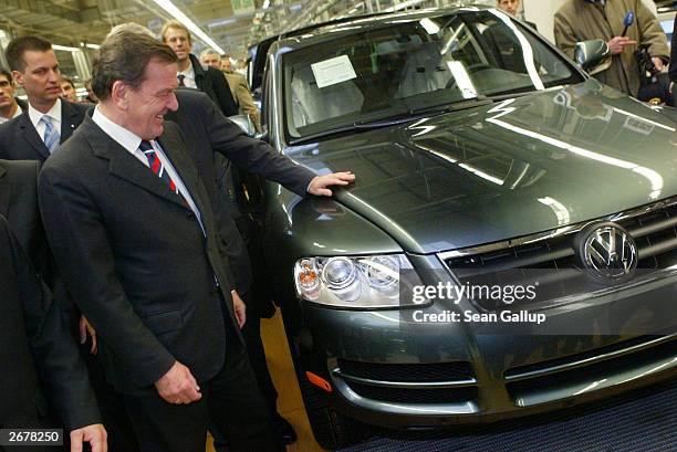German Chancellor Gerhard Schroeder examines a Volkswagen Touareg sport utility vehicle during a tour of a VW factory October 29, 2003 just outside...
