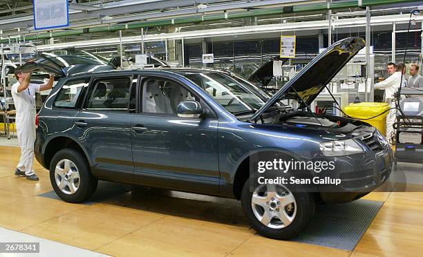 Worker closes the rear door of a Volkswagen Touareg sport utility vehicle October 29, 2003 at the Volkswagen factory just outside Bratislava,...