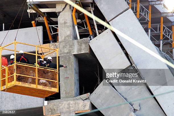 Construction and emergency workers use a lift to try and examine the collapsed decks of a parking garage at the Tropicana Casino and Resort October...