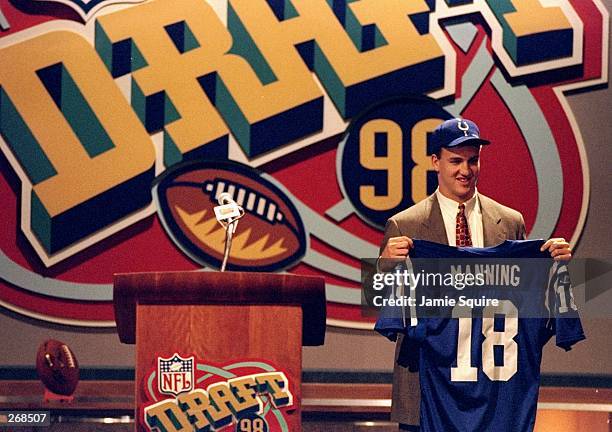 First overall pick Peyton Manning shows off his jersey after being selected by the Indianapolis Colts in the first round of the 1998 NFL Draft at...