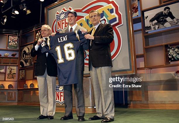 Second overall pick Ryan Leaf shows off his jersey alongside Alex Spanos and commissioner Paul Tagliabue after being selected by the San Diego...
