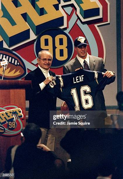 Second overall pick Ryan Leaf shows off his jersey alongside Alex Spanos after being selected by the San Diego Chargers in the first round of the...