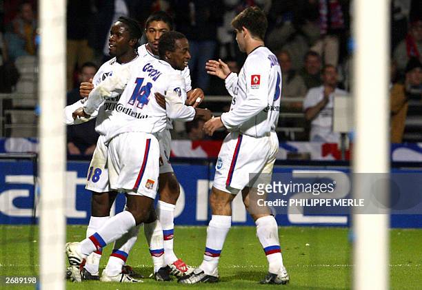 Lyon's forward Sidney Govou is congratulated by his teammates after scoring a goal during their French L1 soccer match against Nice, 01 November 2003...