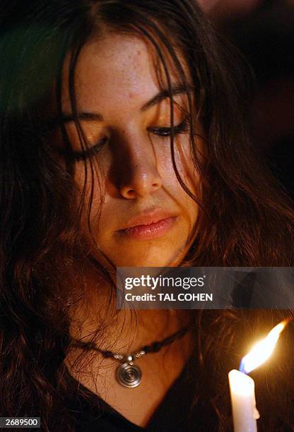 An Israeli woman holds a candle during a rally to mark the eighth anniversary of the assassination of Israeli Prime Minister Yitzhak Rabin in Tel...