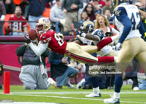 Brandon Lloyd of the San Francisco 49ers catches a touchdown over DeJuan Groce of the St. Louis Rams during an NFL game on November 2, 2003 at...