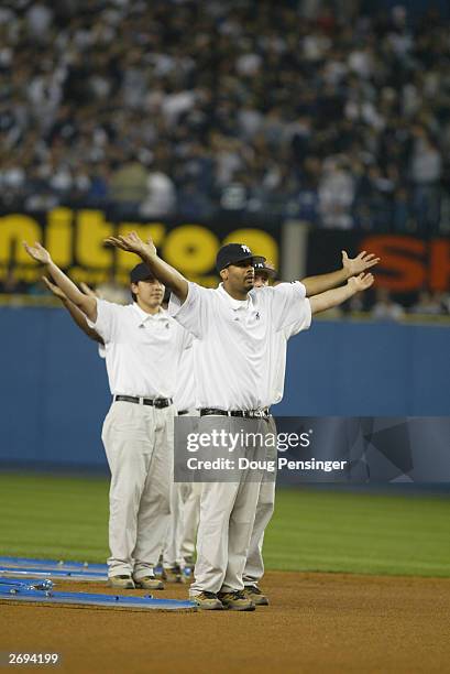 Members of the New York Yankees grounds crew dance to the song "YMCA" during game 1 of the American League Championship Series against the Boston Red...
