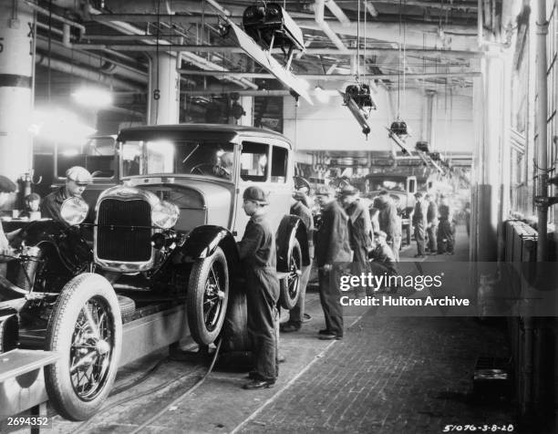 Assembly line workers inside the Ford Motor Company factory at Dearborn, Michigan.