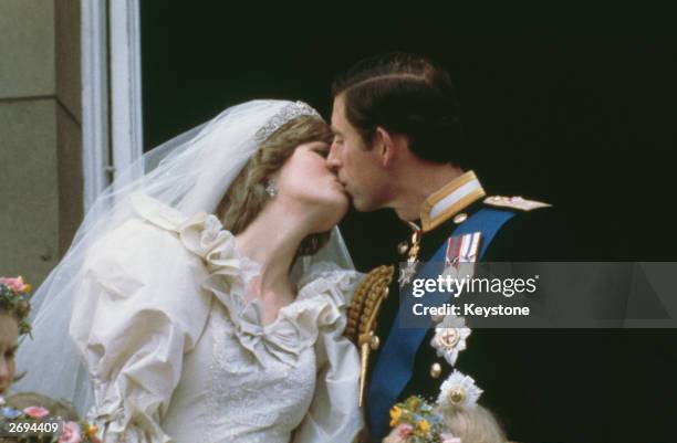 Prince Charles, Prince of Wales, kissing his wife, Princess Diana , on the balcony of Buckingham Palace in London after their wedding, 29th July 1981.