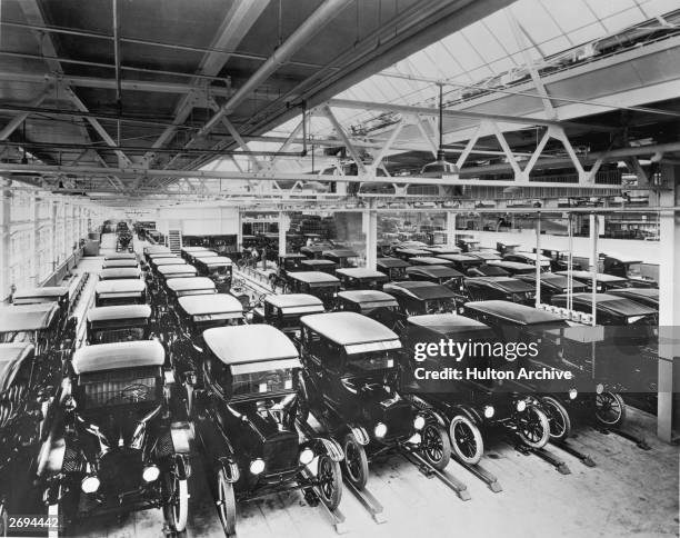 View inside the Ford Motor Company factory with rows of new Model T motor cars.