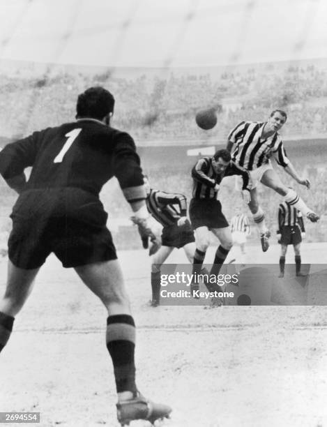Welsh footballer John Charles leaping above two Inter Milan players to score for Juventus.