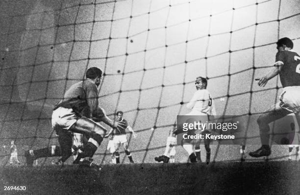 Argentinian born Real Madrid centre forward Alfredo Di Stefano back heels the ball past the Manchester United goalkeeper, Harry Gregg, at Old...