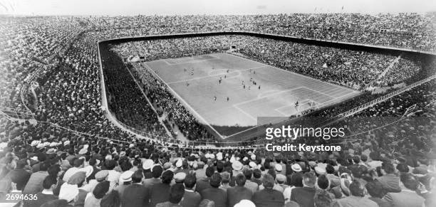 Large crowd watching a football match at the San Siro Stadium in Milan, originally built in 1926.